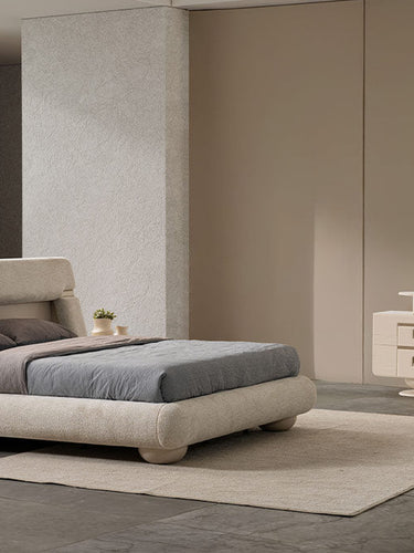 Modern bedroom with a bed, side table, and vanity area.